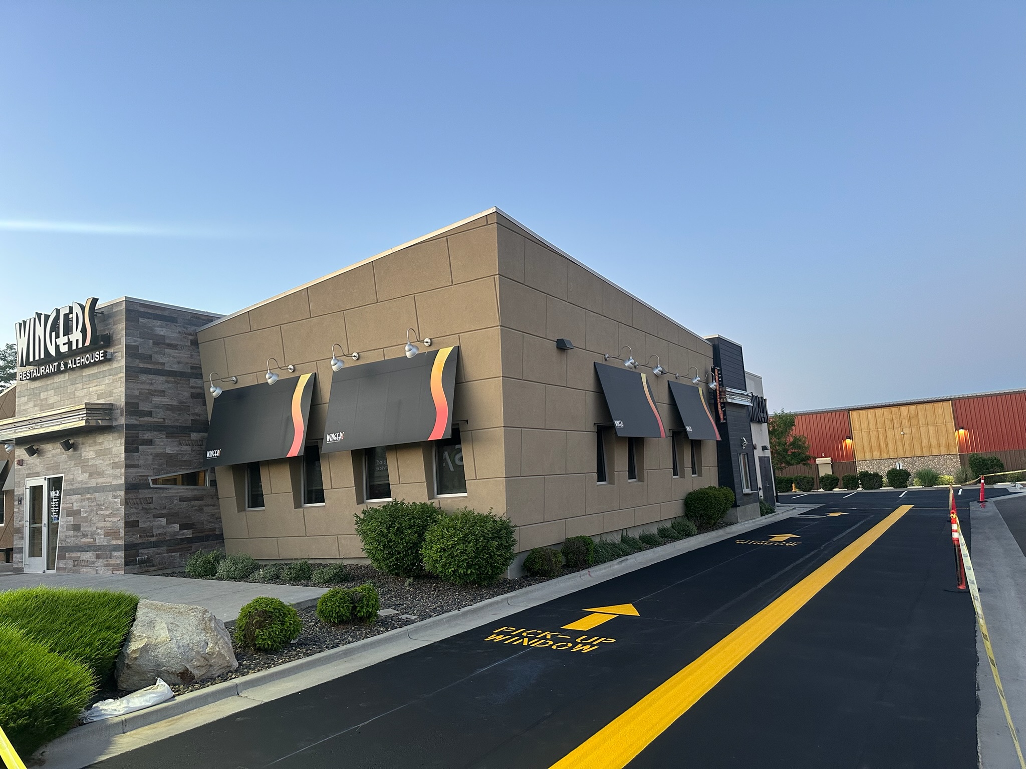 Wingers Restaurant & Alehouse drive-through with fresh sealcoat and yellow directional striping by Supreme Seal Coat in Meridian, Idaho